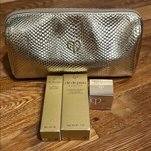 Clé de Peau Beauté Gold Cosmetic Bag with Skincare Products